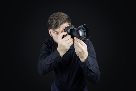 a man in a black shirt and on a black background shows the palms of his hands gestures