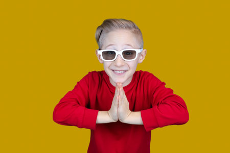a child in children's 3D glasses covered his eyes with his handの写真素材