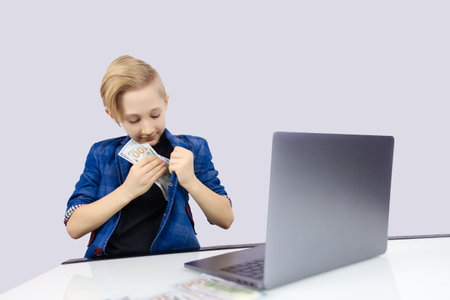 a boy in a jacket is typing on a computerの写真素材