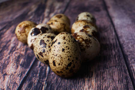 quail eggs in a pink basket on a wooden table top view, eggs for the Easter holidayの写真素材