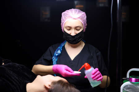 Powder coating of eyebrows in permanent makeup. The master performs eyebrow tattooingの写真素材