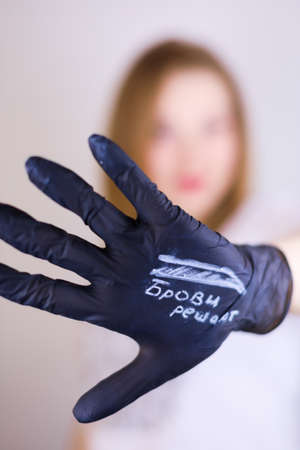 Master of permanent makeup with a tool in his hands on a white backgroundの写真素材