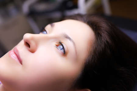 the tattoo artist prepares for the procedure of permanent makeup wraps the pigment holder with a...