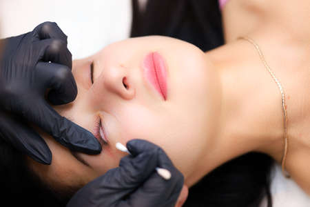 the hands of the master of lamination of cilia perform the procedure of preparing cleaning the interstitial space with a cotton swabの写真素材