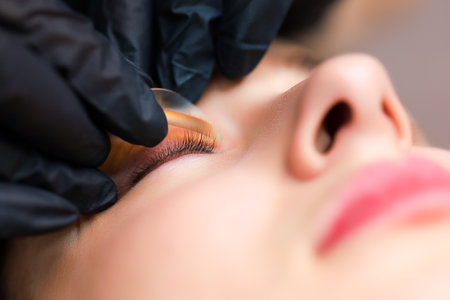 close-up of the model's eye with a curl of cilia the work is done lamination of eyelashes the master combs the cilia with a brushの写真素材