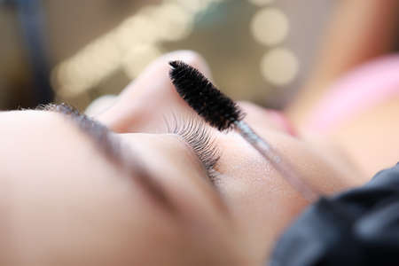 close-up of the model's eye with a curl of cilia the work is done lamination of eyelashes the master combs the cilia with a brushの写真素材