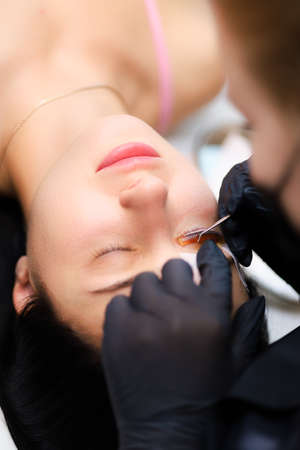 close-up of the model's eye with a curl of cilia the work is done lamination of eyelashes the master combs the cilia with a brushの写真素材