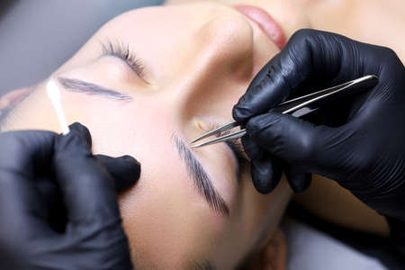removal of the remnants of unwanted eyebrow hairs of the model after the lamination procedure. the...