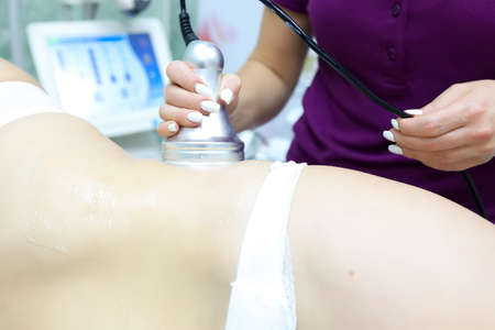 the master works with the abdominal problem removes cellulite with an ultrasonic deviceの写真素材