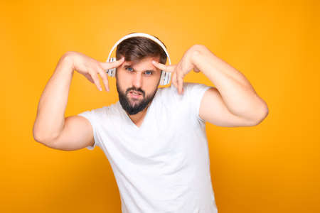bearded man in headphones emotionally performs dance movements to music.の写真素材
