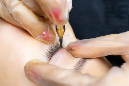 tattoo artist in the process of working on permanent eyelid makeup
