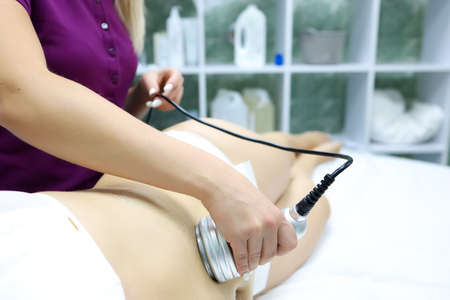 a young model girl in panties lies on the procedure of vacuum massage the master performs the study of problem areasの写真素材