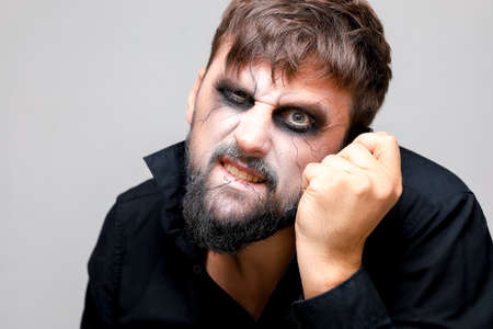 Portrait of a man with a beard and a menacing look with undead-style makeup on All Saints' Day on October 31の写真素材