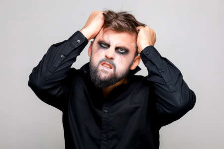 Portrait of a man with a beard and a menacing look with undead-style makeup on All Saints' Day on October 31の写真素材