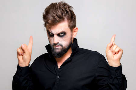 Portrait of a man with a beard and a menacing look with undead-style makeup on All Saints' Day on October 31の写真素材