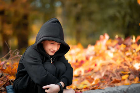 boy - athlete stands at the gate on the football field in autumn.