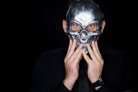 a man in a skeleton mask shows a variety of gestures with his hand