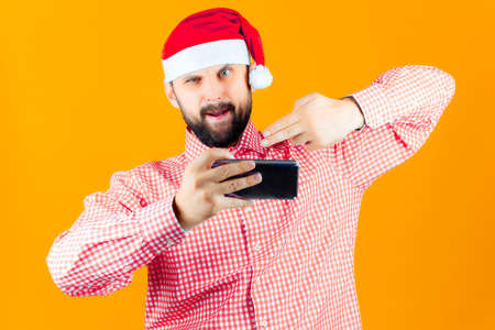 cheerful man in a santa claus hat makes christmas selfiesの写真素材