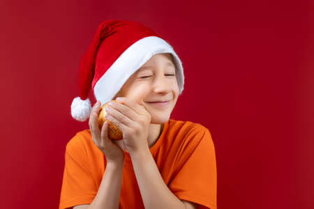 a golden Christmas ball to his face