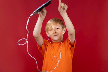 cheerful boy dancing and listening to music through headphonesの写真素材