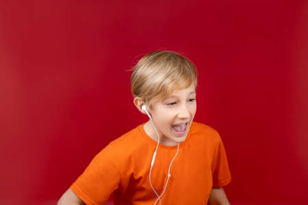 a boy with headphones in his ears stands sideways and singsの写真素材