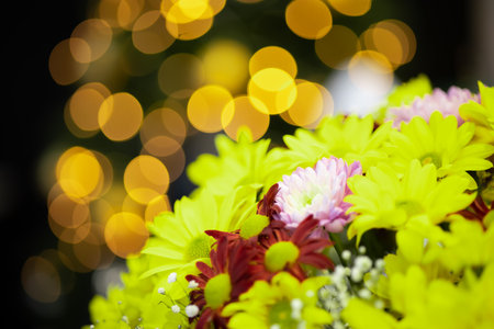 a bouquet of yellow flowers on the background of a Christmas tree that glowsの写真素材