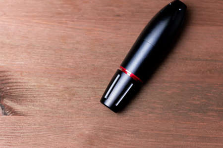 a pen for permanent makeup lies on a wooden tableの写真素材