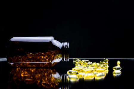 macro photography of a capsule with omega 3 in fish oil that is in a jar