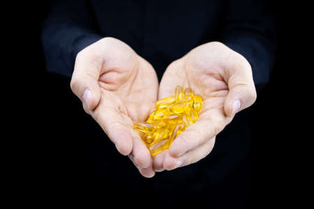 macro photography of a capsule with omega 3 in fish oil that is in a jar