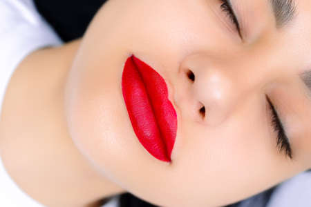model with painted red lips before permanent lip makeup procedure