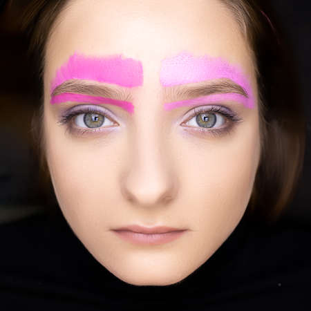model with open eyes, looking at the camera, applied pink eyebrow paste along the contour of the eyebrowsの写真素材