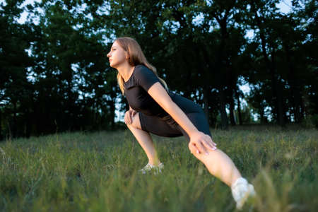 fitness blonde goes in for sports in the park doing leg stretchingの写真素材