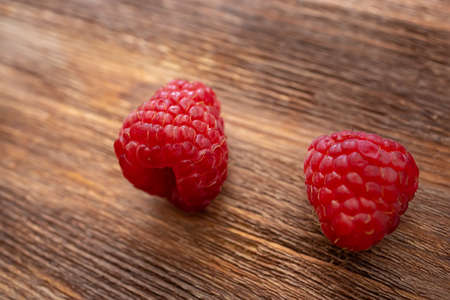 macro shot of a raspberry that lies on a wooden tableの写真素材