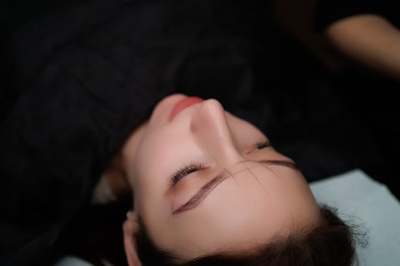 The girl on the procedure of permanent makeup. Eyebrow permanent makeup cosmetic procedure.の写真素材