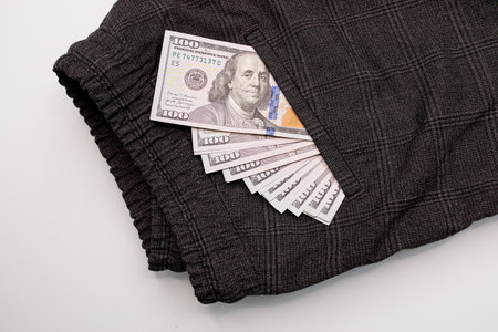 A hundred dollar bill peeks out of his pants pocket. Dollar bills sticking out of your pocket.