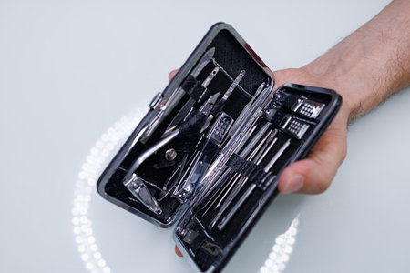 There's a manicure set in a man's hand. A man gives himself a manicureの写真素材