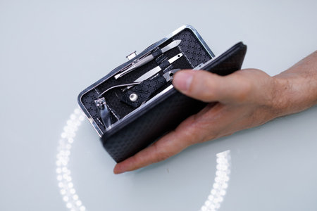 There's a manicure set in a man's hand. A man gives himself a manicure