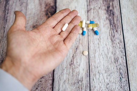 The fingers hold the capsule, nutritional supplements and vitamins.の写真素材