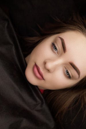 Result after permanent eyebrow makeup correction brunette girl poses on camera. Second PMU procedure...