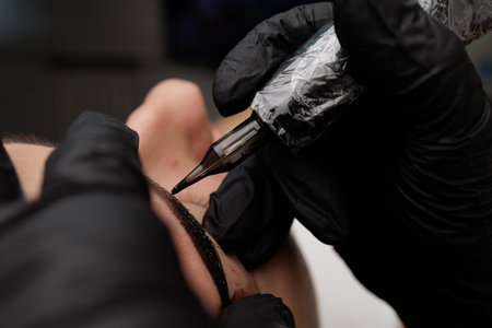 The procedure of permanent eyebrow makeup close-up spout of the cartridge from the machine for tattooing. Permanent eyebrow makeup PMU for brunettesの写真素材