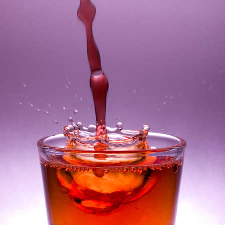 Witer splash in glass full of red whineの写真素材