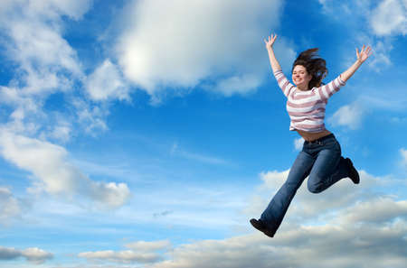 Beautiful woman jumping against blue sky