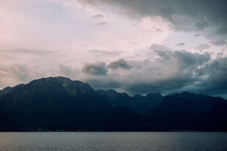 Lake Geneva in late evening and dark mountainsの写真素材
