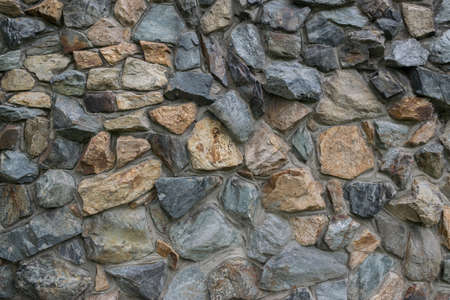 Stone wall texture. Old stone wall with varying sizes, shapes and colored of stones.
