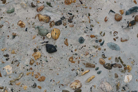 Texture of concrete with multicolored pebbles on the surface. Monolithic concrete wall or garden path with inclusion of multicolored pebbles, high resolution.の写真素材