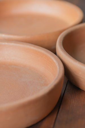 Ketsi on a wooden table. Ketsi, traditional handmade unglazed ceramic cookware, clay round dish, plate, pot, all in one, close-up, high resolution.の写真素材