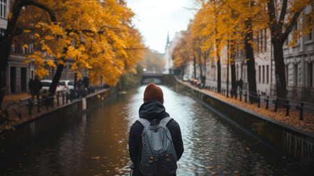 Autumnal Scene of a Person Contemplating a Canal in a European Cityの素材