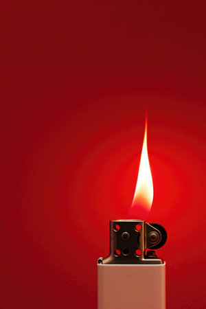 Single Lighter Flame Against a Red Background with Copy Spaceの素材