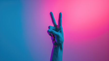 Peace Sign Hand Gesture Against Vivid Pink and Blue Backgroundの素材