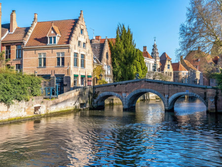 Scenic View of a Tranquil Canal with Brick Bridge in Brugesの素材
